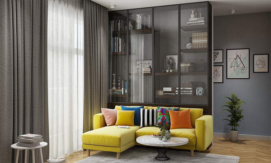 Full Size Floor to Ceiling Glass Almirah design for living room with yellow L-shaped Sofa.